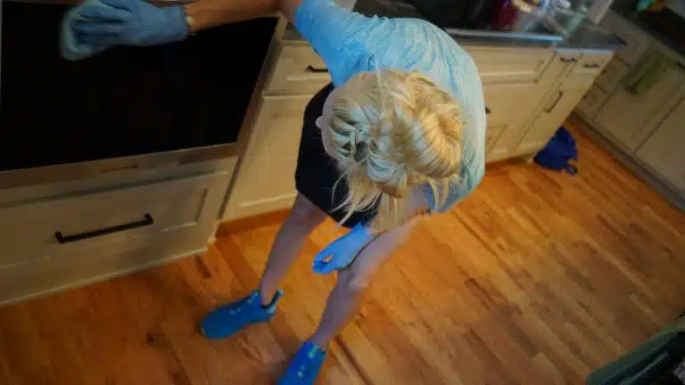 Simply Maid cleaner wiping kitchen cabinets during a move-out clean